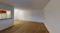 This single-floor unit at 4608 Haverford Pl in Wilmington, DE offers a practical and functional layout across a compact but efficiently designed floor plan. The combined kitchen and living room forms the heart of the unit, with the living area featuring neutral-toned wall-to-wall carpeting, a ceiling fan, and windows fitted with blinds that allow natural light to filter in. Baseboard heating runs throughout, providing consistent warmth.

The kitchen is separated from the living room by a half-wall pass-through with a dark granite-style countertop, creating an open connection between the two spaces. Inside the kitchen, warm-toned wood cabinetry lines the walls, complemented by a mosaic tile backsplash, dark countertops, and white appliances including a refrigerator, electric range, microwave, and sink. Stone-pattern tile flooring and a window above the counter add brightness to the space.

The primary bedroom is a generously sized room with carpeting, a window for natural light, and a full-width closet with louvered bifold doors offering ample storage. The bathroom features marble-style tile surrounding the tub and shower, stone-pattern floor tile, a vanity, and a window for ventilation.