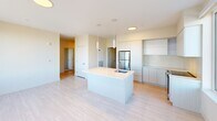 This well-appointed 2-bedroom, 2-bathroom residence in Weymouth, MA offers a thoughtfully designed single-level layout with modern finishes throughout. The open-concept kitchen serves as the heart of the home, featuring a central island with a built-in sink, sleek flat-panel cabinetry, stainless steel appliances, and a herringbone-pattern tile backsplash. Light wood-look flooring flows through the kitchen and into the adjacent living area, which is brightened by multiple large windows offering pleasant outdoor views. The spacious primary bedroom provides generous room for furnishings, complete with dual closets offering ample storage. The second bedroom is equally well-sized with large windows that invite abundant natural light and outdoor views. Both bathrooms are finished with neutral large-format floor tiles and taupe wall tile surrounds — one featuring a soaking tub with a sliding glass enclosure, and the other a walk-in shower. Clean white walls, recessed and pendant lighting, and crisp trim details contribute to a bright, contemporary ambiance. A dedicated closet adds further storage convenience, rounding out this clean and functional Weymouth residence.