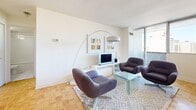 Located at 2021 Avenue Atwater in Montréal's vibrant neighbourhood, this well-appointed one-bedroom, one-bathroom unit offers a thoughtfully designed layout across a single floor. Classic parquet flooring runs throughout, adding warmth and character to the clean, modern aesthetic defined by white walls and abundant natural light.

The open-concept living and kitchen area forms the heart of the unit. The kitchen features light wood cabinetry, a breakfast bar peninsula with granite-style countertops, white appliances, and tile flooring — seamlessly transitioning into the dining and living spaces. Large floor-to-ceiling windows bathe the living area in natural light while framing sweeping views of the Montréal cityscape. The living room comfortably accommodates a seating area and dining space, making it ideal for both relaxation and entertaining.

The bedroom is a generous, serene retreat with its own large window offering city views, built-in closets, and the same warm parquet flooring. A well-maintained bathroom completes the unit, featuring a full bathtub with subway tile surround, a vanity with basin sink, and a wood-accented storage cabinet.

A welcoming hallway connects all areas of the unit. The overall ambiance is bright, clean, and functional — well-suited to urban living in the heart of Montréal.