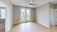 Located at 5067 Elevated View in Chattanooga, Tennessee, this single-floor residence offers a well-organized layout with a clean, contemporary design throughout. Light-toned hardwood-style flooring runs through the main living areas and hallways, creating a cohesive and bright aesthetic, while plush carpet adds warmth to the bedrooms.

The galley-style kitchen is thoughtfully appointed with wood-tone cabinetry, granite-look countertops, stainless steel appliances including a refrigerator and range, an undermount sink, and pendant lighting — offering both style and functionality. The kitchen connects seamlessly to a hallway that leads to the rest of the home.

The living area features French doors that open to a private balcony, allowing natural light to fill the space and providing outdoor views of the surrounding community. Ceiling fans are present in the main living space and bedrooms for year-round comfort.

Bedrooms are carpeted and generously sized, each equipped with a ceiling fan and windows fitted with blinds for natural light and privacy. Closet space includes walk-in storage with wire shelving systems.

The bathroom features a full tub and shower combination with a clean white surround, a vanity with granite-look countertops, dark wood cabinetry, and light hardwood-style flooring. The neutral gray walls throughout the home provide a versatile backdrop suited to a variety of furnishing styles.