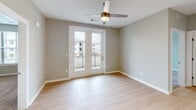 Located at 5067 Elevated View in Chattanooga, Tennessee, this single-floor residence offers a well-organized layout with a clean, contemporary design throughout. Light-toned hardwood-style flooring runs through the main living areas and hallways, creating a cohesive and bright aesthetic, while plush carpet adds warmth to the bedrooms.

The galley-style kitchen is thoughtfully appointed with wood-tone cabinetry, granite-look countertops, stainless steel appliances including a refrigerator and range, an undermount sink, and pendant lighting — offering both style and functionality. The kitchen connects seamlessly to a hallway that leads to the rest of the home.

The living area features French doors that open to a private balcony, allowing natural light to fill the space and providing outdoor views of the surrounding community. Ceiling fans are present in the main living space and bedrooms for year-round comfort.

Bedrooms are carpeted and generously sized, each equipped with a ceiling fan and windows fitted with blinds for natural light and privacy. Closet space includes walk-in storage with wire shelving systems.

The bathroom features a full tub and shower combination with a clean white surround, a vanity with granite-look countertops, dark wood cabinetry, and light hardwood-style flooring. The neutral gray walls throughout the home provide a versatile backdrop suited to a variety of furnishing styles.