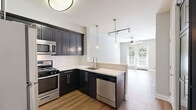 Located in the heart of Hollywood at 1638 Franklin Ave, this efficiently designed single-floor unit offers a thoughtful layout that maximizes every square foot. The open-concept floor plan seamlessly connects the kitchen and living area, creating a cohesive and functional living space.

The kitchen is a standout feature, showcasing dark shaker-style cabinetry paired with crisp white quartz countertops and a classic white subway tile backsplash. A full suite of stainless steel appliances — including a gas range, microwave, refrigerator, and dishwasher — provides modern convenience. Pendant lighting over the peninsula adds style while enhancing the open feel between the kitchen and living area.

The living room is bright and welcoming, benefiting from natural light that streams through French doors leading to the outdoors. Warm hardwood-style flooring runs throughout, and a ceiling fan adds comfort year-round. The neutral gray walls provide a versatile backdrop for any décor.

The bathroom features large-format tile flooring in a rich wood-tone finish and includes a soaking tub with shower combination, offering a clean and functional design. An additional closet provides practical storage. The overall aesthetic is modern and move-in ready, ideal for those seeking a streamlined lifestyle in a prime Los Angeles location.