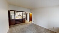 Located at 5555 McIntosh Ct in Dayton, Ohio, this single-floor, one-bedroom, one-bathroom unit offers a practical and functional layout. The living area features neutral-toned carpet, white walls, and a front entry door flanked by a window that allows natural light to fill the space. A distinctive dark wood room divider with open shelving separates the living area from the kitchen, creating a semi-open pass-through design. The kitchen is equipped with light wood-tone countertops, white cabinetry, a gas range, a full-size refrigerator, and tile flooring, providing ample workspace for everyday cooking. The bedroom is a comfortable size, with carpeted floors, a ceiling fan with light fixture, crown molding, and a window with blinds that offers an outdoor view. Warm wood-toned bi-fold closet doors provide generous storage. The bathroom includes a full tub-shower combination with chrome fixtures and a clean, functional design. A dedicated utility room adds practical value. Throughout the unit, warm brown door and trim accents provide a consistent design thread, giving the space a cohesive, classic character well-suited for comfortable everyday living.