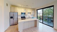 Located at 2832 Girard Ave S in Minneapolis's vibrant Uptown neighborhood, this single-floor residence offers a thoughtfully designed layout with contemporary finishes and an abundance of natural light. The open-concept kitchen serves as a central highlight, featuring light wood cabinetry, white quartz countertops, a classic subway tile backsplash, and a full suite of stainless steel appliances including a refrigerator, range, and microwave. A spacious island provides additional prep and seating space, while pendant and track lighting create a warm, functional atmosphere. Large sliding glass doors open directly to a private balcony, blending indoor and outdoor living seamlessly and offering views of the surrounding neighborhood. The bedroom is bright and airy, with floor-to-ceiling windows that invite generous natural light and provide access to the balcony, complemented by light hardwood-style flooring that runs throughout the unit. The bathroom is finished in a clean, modern palette with light wood vanity cabinetry, a white quartz countertop, a large framed mirror, and a tub-shower combination. Crisp white walls and consistent light flooring unify the space, creating a cohesive, contemporary aesthetic that is both inviting and functional.