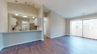 Located at 1204 Sherwood Ct in Rochester Hills, Michigan, this single-floor residence offers a thoughtfully designed layout with a blend of modern finishes and comfortable living spaces. The open-concept living and dining area is highlighted by soaring vaulted ceilings and rich, dark hardwood-style flooring that extends throughout the main living spaces. A sliding glass door floods the room with natural light and provides access to the outdoors. The kitchen is well-appointed with crisp white shaker-style cabinetry, granite countertops, a classic white subway tile backsplash, stainless steel appliances, and a breakfast bar peninsula — ideal for casual dining and entertaining. A built-in open pantry shelf adds convenient storage. The bedrooms feature plush wall-to-wall carpeting and windows that invite natural light. The bathrooms are finished with granite vanity countertops, large-format tile surround, and include both a soaking tub and a separate walk-in shower with glass doors. An in-unit laundry area accommodates a full-size washer and dryer. The neutral color palette and clean design throughout create a bright, welcoming ambiance suited for a variety of lifestyles.