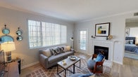 This single-floor residence offers a thoughtfully designed layout that balances comfort and functionality across its key living spaces. The living room serves as the heart of the home, characterized by crown molding, light wood-style flooring, and a tiled fireplace framed by a classic white mantel. A large picture window and a glass-paned exterior door flood the space with natural light while offering views of the surrounding greenery, creating an inviting and airy atmosphere.

Adjacent to the living area, a dedicated dining space features light wood flooring that continues throughout, providing a seamless visual flow. The kitchen is well-equipped with white cabinetry, light quartz countertops, a subway tile backsplash, stainless steel appliances, and a stainless undermount sink — combining a clean aesthetic with practical functionality.

The bedrooms are generously proportioned, each featuring plush carpet flooring and sliding or hinged closets that offer ample storage. The neutral color palette throughout promotes a calm, versatile environment. The bathroom is finished with a white vanity, light wood-style flooring, and a well-lit mirror above the sink, maintaining the home's clean and cohesive design throughout.