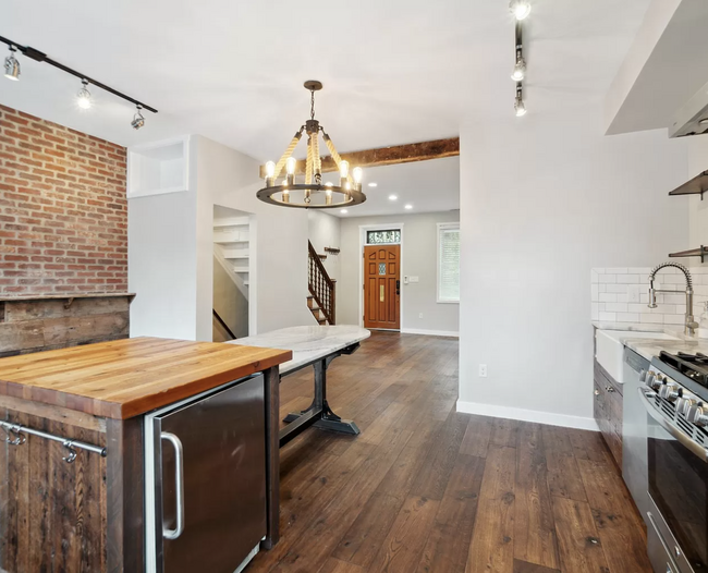 Custom wide plank hardwood flooring across the main level, with custom mont blanc granite table. - 829 3rd St NE