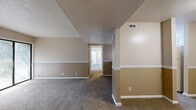 Located at 2301 Arkansas Blvd in Texarkana, AR, this single-floor residence offers two bedrooms and two full bathrooms within a well-organized layout. The living room serves as the heart of the home, featuring a classic fireplace, a textured ceiling, and a wide sliding glass door that invites natural light and provides outdoor views. Warm-toned, two-tone painted walls with white chair rail trim run throughout the main living areas, complemented by neutral carpeting underfoot.

The kitchen is designed in a galley-style layout, outfitted with white cabinetry, light countertops, a double-basin sink with a modern faucet, and white appliances including a coil-top range and dishwasher. Wood-look vinyl flooring adds a practical and clean finish to this space. A pass-through connects the kitchen to the main living and dining area.

Both bedrooms are carpeted and offer dedicated closets with shelving for ample storage. The primary bedroom includes a ceiling fan with light fixture and its own closet access. Each bathroom features wood-look vinyl flooring, a vanity with white cabinetry, light countertops, and a shower-tub combination. Two hallways provide a logical flow connecting all areas of the residence, enhancing the functional single-floor plan.