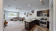 Located at 700 Darely Green Dr in Claymont, Delaware, this thoughtfully designed one-bedroom, one-bathroom residence offers a comfortable and functional single-floor layout. The open-concept kitchen and living area serves as the heart of the home, featuring rich dark cabinetry, stainless steel appliances, a gas range, and a granite peninsula with bar seating — ideal for both cooking and casual dining. Track lighting and hardwood-style flooring add a modern touch to the kitchen space, which also includes a convenient in-unit stacked washer and dryer. The living room is bright and welcoming, with multiple windows that invite abundant natural light and views of the surrounding greenery. Soft carpeting and a neutral color palette create a relaxed, versatile ambiance throughout. The generously sized primary bedroom offers a serene retreat, complete with French doors that open to the outdoors, plush carpeting, and direct access to the walk-in closet outfitted with wire shelving. The bathroom features a large vanity with a white countertop, dark cabinetry, and a wide mirror with overhead lighting. Clean lines and a cohesive design aesthetic tie the entire space together, making it a practical and inviting place to call home.