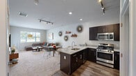 Located at 700 Darely Green Dr in Claymont, Delaware, this thoughtfully designed one-bedroom, one-bathroom residence offers a comfortable and functional single-floor layout. The open-concept kitchen and living area serves as the heart of the home, featuring rich dark cabinetry, stainless steel appliances, a gas range, and a granite peninsula with bar seating — ideal for both cooking and casual dining. Track lighting and hardwood-style flooring add a modern touch to the kitchen space, which also includes a convenient in-unit stacked washer and dryer. The living room is bright and welcoming, with multiple windows that invite abundant natural light and views of the surrounding greenery. Soft carpeting and a neutral color palette create a relaxed, versatile ambiance throughout. The generously sized primary bedroom offers a serene retreat, complete with French doors that open to the outdoors, plush carpeting, and direct access to the walk-in closet outfitted with wire shelving. The bathroom features a large vanity with a white countertop, dark cabinetry, and a wide mirror with overhead lighting. Clean lines and a cohesive design aesthetic tie the entire space together, making it a practical and inviting place to call home.