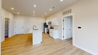 Located at 8484 Brougham Dr in Sterling Heights, Michigan, this well-appointed 2-bedroom, 3-bathroom unit offers a thoughtfully designed single-floor layout with a clean, modern aesthetic. Light-toned hardwood flooring runs throughout the entire space, complementing the neutral, warm-white wall palette and creating a bright, cohesive look from room to room.

The kitchen serves as the heart of the home, showcasing white shaker-style cabinetry, stainless steel appliances including a refrigerator, range, and microwave, and a central island with a white countertop and matte black sink faucet. Recessed lighting illuminates the space effectively, enhancing the open-concept feel.

The bathrooms feature consistent modern finishes, including matte black hardware and fixtures. One bathroom includes a sleek glass-enclosed walk-in shower with built-in shelving, while another offers a white vanity with an undermount sink, framed mirror, and contemporary lighting.

Both bedrooms are bright and airy, each benefiting from windows fitted with horizontal blinds that allow for natural light and outdoor views. The primary bedroom offers a generous footprint with ample room for furnishings. A dedicated utility closet houses a stacked washer and dryer alongside a water heater, adding practical convenience. Overall, the space delivers a fresh, modern living experience with functional design throughout.