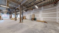 Located at 700 N Delaware Ave in Philadelphia's vibrant Northern Liberties neighborhood, this ground-floor commercial shell space comprises two combined suites delivering a generously expansive, wide-open floor plan ideal for a variety of build-to-suit uses. The interior showcases an industrial aesthetic characterized by exposed corrugated metal ceilings with visible structural beams, ductwork, and utility runs overhead, lending the space a raw, loft-like character with impressive ceiling heights throughout. Polished concrete floors extend across the entire footprint, providing a durable and versatile base ready for customization. A striking series of large, black-framed windows lines multiple exterior walls, flooding the interior with abundant natural light and offering views of the surrounding urban streetscape. Street-facing storefront glazing with black-framed floor-to-ceiling glass panels provides prominent visibility and direct access from N Delaware Ave. Structural columns punctuate the open layout at regular intervals, adding to the industrial character while defining potential zones within the space. The shell condition presents a blank canvas, with drywall in progress and mechanical systems roughed in, making this an exceptional opportunity for tenants seeking a highly adaptable, light-filled commercial space in one of Philadelphia's most dynamic neighborhoods.