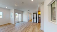 Located on Hi Point Street in Los Angeles, this single-floor unit offers a clean, contemporary design throughout. Light oak hardwood flooring runs continuously across all rooms, creating a cohesive and airy feel. The open living area is bright and spacious, with recessed lighting overhead and multiple windows that invite natural light and neighborhood views. Sliding glass doors lead to a private balcony, extending the living space outdoors.

The kitchen is a standout feature, finished with warm yellow cabinetry, crisp white quartz countertops, a stainless steel gas range with an overhead hood, and a striking blue-and-white patterned tile backsplash. A deep undermount sink with a matte black faucet completes the well-appointed space.

The unit includes two bathrooms, each featuring a tub-shower combination enclosed by sliding glass doors with dark matte black frames, white subway-style tile surround, and matching wood-toned flooring. One bathroom includes a vanity with warm wood cabinetry.

Bedrooms are generously sized with crisp white walls and windows offering outdoor views. A stacked washer and dryer is conveniently located within the unit, adding practical functionality to this thoughtfully designed Los Angeles residence.