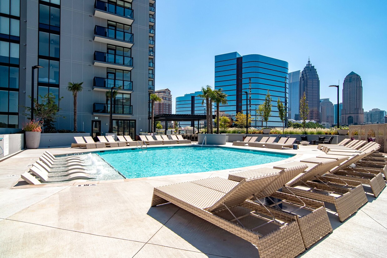 Piscina de lujo con chaise lounges y cabañas. - Ascent Midtown