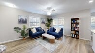 Located at 4129 Hearthside Dr in Wilmington, NC, this single-floor, 3-bedroom, 2-bathroom home offers a well-organized and comfortable layout. The entryway welcomes you with light wood-look flooring and a textured ceiling, setting a warm tone throughout the common areas. The living room is bright and inviting, featuring a ceiling fan, large windows with natural light, and sliding glass doors that open to a private balcony with outdoor views. Adjacent to the living room, the combined dining and kitchen area is thoughtfully designed. The kitchen boasts white shaker cabinets, granite countertops, stainless steel appliances, and a peninsula with sink. The dining nook benefits from dual windows and a pendant light overhead. The primary bedroom includes carpet flooring, a ceiling fan, and sliding glass door access to the outdoors. The two additional bedrooms are carpeted and well-lit with ceiling fans. Both bathrooms feature granite vanity countertops and clean, bright finishes, including a shower-tub combination. The home also includes a dedicated laundry room, utility room, a hallway connecting the bedrooms, and ample closet storage throughout—five closets in total.