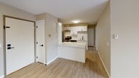 Located at 407 E Seventh St in Monticello, Minnesota, this single-floor unit has been thoughtfully updated throughout, combining modern finishes with a functional, comfortable layout. Light-toned luxury vinyl plank flooring runs seamlessly throughout the space, creating a cohesive and easy-to-maintain foundation.

The kitchen is a standout feature, boasting white shaker-style cabinetry with matte black hardware, white quartz countertops, a classic subway tile backsplash, and stainless steel appliances including a refrigerator and electric range. A peninsula counter provides additional prep space and opens toward the living and dining area, encouraging an open, connected feel.

The spacious living room is bathed in natural light from a large sliding glass door that leads directly to a private balcony with outdoor views. A ceiling fan and baseboard heating add year-round comfort to this generous gathering space.

The bedrooms are well-proportioned, each featuring warm neutral walls and ample closet space, including a walk-in closet in one room. The full bathroom has been updated with a white vanity, quartz countertop, matte black fixtures, and a tub-shower combination. Neutral beige tones throughout the unit create a calm, move-in-ready ambiance.