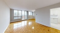 Located at 560 Birchmount Road in Toronto's Scarborough area, this well-appointed 2-bedroom, 1-bathroom unit offers a comfortable and functional layout across a single floor. The open living room is a highlight of the space, featuring warm parquet flooring and expansive floor-to-ceiling windows that flood the room with natural light and frame sweeping city views. A sliding door provides access to a private balcony, extending the living area outdoors. The galley-style kitchen has been tastefully renovated with crisp white cabinetry, marble-effect countertops, a classic tile backsplash, gleaming white tile floors, and stainless steel appliances including a refrigerator and range. Both bedrooms continue the parquet flooring theme and are fitted with sliding-door closets, offering practical storage solutions. The primary bedroom is generously proportioned and benefits from a dedicated window with city views and a baseboard heating unit. The bathroom features white tile flooring and a marble-top vanity. Connecting hallways provide a logical flow throughout the unit. The consistent use of neutral tones, natural wood flooring, and bright finishes gives the space a clean, cohesive aesthetic throughout.