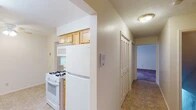 Located at 64 Forest Garden Dr in Youngstown, Ohio, this three-floor home offers a practical and well-organized layout across its levels. The kitchen is a galley-style space equipped with white appliances, including a gas range, refrigerator, microwave, and dishwasher. Light wood cabinetry lines both walls, providing ample storage, while laminate countertops and tile flooring complete the functional design. A window allows natural light to filter into the space.

The main living areas feature plush carpeting and neutral-toned walls, creating a warm and understated ambiance. Crown molding accents the ceiling in the primary living room, adding a refined architectural detail. Carpeted bedrooms offer generous storage through double bifold closets. One bedroom features a window with views of autumn foliage, bringing natural scenery indoors.

Bathrooms are appointed with white undermount sinks, wood-framed mirrors, and overhead lighting. A hallway lined with louvered closet doors provides additional storage between rooms.

The lower level includes an unfinished basement with a painted concrete floor, exposed wooden joists, ductwork, an electrical panel, and glass block windows, offering practical utility space with potential for future use. A staircase with a decorative railing connects the floors throughout the home.