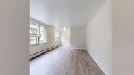 Located on the 7th floor at 437 Jarvis St in the heart of Toronto, this one-bedroom, one-bathroom suite offers a practical and well-laid-out floor plan across a single level. The living room is a bright, open space finished with light-toned luxury vinyl plank flooring and multiple windows that frame views of the surrounding cityscape, allowing generous natural light to fill the room throughout the day. A baseboard heating system runs along the exterior wall, ensuring warmth during cooler months.

The spacious primary bedroom features classic parquet hardwood flooring in a warm honey tone, adding timeless character to the room. A set of sliding closet doors provides ample built-in storage, while a window offers an outlook onto the neighbouring architecture. The hallway connecting the rooms is clean and functional, leading to the full bathroom, which is finished with white ceramic wall tiles, a soaking bathtub, pedestal sink, and a window that admits natural light. A dedicated laundry area with overhead shelving rounds out the unit's practical amenities. Neutral walls throughout the suite create a clean, versatile backdrop suited to a variety of décor styles.