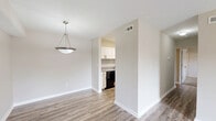 Located at 150 Continental St in Anderson, SC, this well-appointed 2-bedroom, 3-bathroom residence offers a practical and comfortable single-floor layout. The open living area is finished with wood-look luxury vinyl flooring and neutral warm-toned walls, creating a bright and cohesive atmosphere. Sliding glass doors lead directly to a private balcony, allowing natural light to pour in and providing pleasant outdoor views. A pendant light fixture anchors the transition between the living and kitchen areas, adding a subtle decorative touch. The galley-style kitchen is outfitted with white shaker cabinetry featuring matte black hardware, stone-patterned countertops, a stainless steel double sink, and black appliances including a range, refrigerator, and dishwasher — all set atop matching wood-look flooring. Both bedrooms are generously sized and feature soft wall-to-wall carpeting, neutral walls, and ample natural light from windows. The primary bedroom includes two separate doors, offering access to a closet and a connected hallway. Each bedroom benefits from ceiling-mounted light fixtures. The three bathrooms are clean and functional, with one featuring a full tub-shower combination with brushed gold fixtures. The hallway connects all rooms efficiently, completing this thoughtfully designed home.