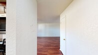 Summit West Two Bedroom B1, Unit 17D, is a thoughtfully laid-out single-floor residence offering two bedrooms, a well-appointed kitchen, and comfortable living spaces throughout. Rich hardwood-style flooring flows consistently across the living areas, bedrooms, and hallways, lending warmth and continuity to the interior.

The kitchen is a standout feature, showcasing rich cherry wood cabinetry with ample storage, dark granite countertops, and a full suite of stainless steel appliances including a side-by-side refrigerator with ice and water dispenser, a dishwasher, a range, and a built-in microwave. Light hardwood flooring and a recessed ceiling with overhead lighting complete the kitchen's polished look.

The open living area benefits from a sliding glass door that connects to a covered private patio, allowing natural light to fill the room. A ceiling fan with light fixture adds comfort and airflow. Both bedrooms are well-proportioned, each featuring ceiling fans, windows with natural light, and hardwood-style flooring. One bedroom includes a walk-in closet for added storage convenience.

The bathroom is finished with dark granite countertops, a rich wood vanity, a large mirror with Hollywood-style lighting, and a tiled tub-and-shower combination with warm earth-toned tile and a decorative accent border. The private patio offers open sky views, providing an outdoor retreat.