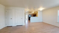 This single-floor unit offers a thoughtfully designed layout that balances open living spaces with functional private areas. The living room is generously sized, featuring light hardwood-style flooring, neutral walls, and a large window that allows natural light to brighten the space while offering views of the surrounding exterior.

The kitchen is well-equipped with dark espresso cabinetry, black appliances including a refrigerator and range, light stone-finish countertops, a double-basin sink, and pendant lighting overhead. A half-wall peninsula connects the kitchen to the living area, creating an open, connected feel ideal for entertaining or everyday living.

The bedrooms are carpeted for comfort and include ample natural light from windows with blinds. The primary bedroom features a spacious walk-in closet and direct access to the bathroom. An additional bedroom provides a quiet, versatile space suitable for sleeping, a home office, or a guest room.

A secondary area with hardwood-style flooring includes multiple closets, offering excellent built-in storage solutions. The bathroom is designed with accessibility in mind, featuring grab bars near the toilet and bathtub/shower combination, a vanity with a light countertop, and easy-maintenance flooring. Throughout the unit, recessed and flush-mount ceiling lighting provides consistent illumination in every room.