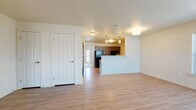 This single-floor unit offers a thoughtfully designed layout that balances open living spaces with functional private areas. The living room is generously sized, featuring light hardwood-style flooring, neutral walls, and a large window that allows natural light to brighten the space while offering views of the surrounding exterior.

The kitchen is well-equipped with dark espresso cabinetry, black appliances including a refrigerator and range, light stone-finish countertops, a double-basin sink, and pendant lighting overhead. A half-wall peninsula connects the kitchen to the living area, creating an open, connected feel ideal for entertaining or everyday living.

The bedrooms are carpeted for comfort and include ample natural light from windows with blinds. The primary bedroom features a spacious walk-in closet and direct access to the bathroom. An additional bedroom provides a quiet, versatile space suitable for sleeping, a home office, or a guest room.

A secondary area with hardwood-style flooring includes multiple closets, offering excellent built-in storage solutions. The bathroom is designed with accessibility in mind, featuring grab bars near the toilet and bathtub/shower combination, a vanity with a light countertop, and easy-maintenance flooring. Throughout the unit, recessed and flush-mount ceiling lighting provides consistent illumination in every room.