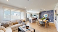 Located at 400 Stanford Crossing in Lathrop, CA, this well-appointed two-story home offers 3 bedrooms and 4 bathrooms across two thoughtfully designed floors. The main level hosts an open-plan living, dining, and kitchen area bathed in natural light through plantation-shuttered windows. The kitchen stands out with sage-green shaker cabinetry, white quartz countertops, a central island with seating, subway tile backsplash, stainless steel appliances, and stylish pendant lighting. The adjacent dining and living areas flow seamlessly, featuring light wood flooring that runs throughout. A striking floral-print accent wall adds character near the entryway hallway. Upstairs, the generously sized primary bedroom offers a serene retreat with soft neutral tones, large windows, and ample space. Two additional bedrooms are bright and well-proportioned, each with multiple windows. The bathrooms are finished with clean white vanities, wide mirrors, and frosted glass shower doors. A dedicated laundry room with side-by-side washer and dryer adds everyday convenience. With two hallways, a closet, and a staircase connecting the floors, this home balances modern design with functional, comfortable living.