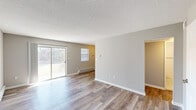 This single-floor residence at 129 Estates Blvd in Trenton, NJ offers a clean, updated interior with a neutral color palette and practical layout throughout. The main living area is notably open and bright, featuring light-toned wood-look flooring, textured ceilings, and a full wall of sliding glass doors that flood the space with natural light while providing direct views of the surrounding greenery. Baseboard heating runs along the perimeter walls, ensuring efficient climate control throughout the unit.

The kitchen is well-appointed with white shaker-style cabinetry, dark stone-look countertops, a subway tile backsplash, and stainless steel appliances. A stacked washer and dryer unit is conveniently integrated into the kitchen area, adding practical in-unit laundry capability.

The bedrooms are generously sized, with plush carpeting underfoot and multiple windows that bring in ample natural light. Each room features baseboard heating and textured ceilings consistent with the rest of the unit.

The bathroom presents a polished finish with grey cabinetry, a granite-topped vanity, a mirrored medicine cabinet, and clean white tile flooring. The overall ambiance of the space is bright, functional, and move-in ready, with updated finishes lending a fresh, contemporary feel.