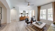 Located in Houston, TX, this 2-bedroom, 1-bathroom residence offers a thoughtfully designed single-floor layout that maximizes comfort and functionality. The living room is bright and welcoming, featuring light wood-look flooring, crown molding, a ceiling fan, and large windows with outdoor views that flood the space with natural light. Elegant arched doorways connect the living area to the dining room, which offers a dedicated space ideal for entertaining. The kitchen is a standout, outfitted with white shaker cabinetry, dark granite countertops, a striking mosaic tile backsplash, stainless steel appliances, and a breakfast bar with seating. A dedicated dining area provides additional space for meals and gatherings. The primary bedroom features textured accent walls and plush carpeting, creating a cozy retreat. The bathroom is clean and modern, with a dark granite vanity, white cabinetry, a large mirror, and a tub-shower combination with tile surround. Additional rooms include a closet, laundry area, and two hallways that connect the space efficiently. A private outdoor access point with large windows ensures the home remains bright and connected to its surroundings throughout.