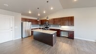 Located at 2640 47th St S in Fargo, North Dakota, this single-floor residence combines modern finishes with a functional, open layout. The kitchen serves as a central highlight, showcasing rich dark-wood cabinetry that extends to the ceiling, granite countertops, and a full suite of stainless steel appliances including a refrigerator, range, and microwave. A large center island with an undermount sink and additional storage provides ample prep space, while pendant lighting and a gray tile backsplash add contemporary style. Vaulted ceilings in the kitchen enhance the sense of openness throughout.

The living area offers a clean, light-filled environment with wide-plank hardwood-style flooring, a large window that invites natural light, and a striking fireplace framed by a reclaimed wood-style accent wall — a clear focal point of the space. Carpeted bedrooms provide a softer feel, with neutral tones and windows offering natural light. The bathroom features granite-topped dark wood vanity cabinetry, a full tub and shower combination, and wood-style flooring for a cohesive look. A dedicated laundry room accommodates a full-size washer and dryer with overhead shelving for added storage convenience.