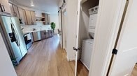 This 450 square foot apartment in Fargo, North Dakota, offers a thoughtfully designed living space that maximizes functionality and style. The single-floor layout comprises three distinct areas, each tailored for comfort and efficiency.

The kitchen is a standout feature, boasting sleek, light-colored cabinetry with ample storage. Stainless steel appliances, including a side-by-side refrigerator, built-in microwave, and electric range, complement the modern aesthetic. A striking hexagonal tile backsplash adds visual interest, while quartz countertops provide a durable work surface.

The bedroom, though compact, exudes comfort with a plush, upholstered headboard and neutral bedding. A contemporary art piece adorns the wall, adding a touch of sophistication. Thoughtful lighting, including a floor lamp, creates a warm ambiance.

The living area features mid-century inspired furniture, including leather armchairs and a wooden coffee table. A large window floods the space with natural light and offers views of the surroundings. The room is accented by modern artwork and a cozy area rug.

Throughout the apartment, light wood flooring unifies the space, while recessed lighting and strategically placed lamps ensure ample illumination. The bathroom, while not pictured in detail, appears to maintain the same modern, clean aesthetic evident throughout the home.

This apartment demonstrates that small-space living can be both stylish and functional, offering a perfect blend of comfort and contemporary design in the heart of Fargo.