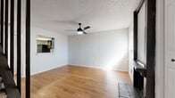 This two-story, 2-bedroom, 2-bathroom home is located in Austin's sought-after 78704 neighborhood. The main floor hosts an open-concept kitchen and living area with warm hardwood-style flooring throughout. The living room is anchored by a classic wood-burning brick fireplace and features a ceiling fan with light, a window for natural light, and a pass-through kitchen window. The kitchen is equipped with dark cabinetry, a gas range, refrigerator, dishwasher, and a skylight-style ceiling fixture that brightens the space. Vertical blinds offer privacy near the patio access. A utility room and a full bathroom with a tub/shower combo round out the first floor. Upstairs, both bedrooms feature plush carpet, ceiling fans, natural light from windows, and dedicated closets with built-in rods for ample storage. The primary bedroom is generously sized with a dedicated closet. A hallway connects the upper-level rooms, and a staircase links the two floors. With four closets throughout, storage is plentiful. A private patio adds outdoor living space, completing this well-appointed Austin home.