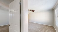 Located at 1800 FM 1092 Rd in Missouri City, TX, this single-story, three-bedroom, two-bathroom home offers a well-organized layout designed for everyday functionality. The living area features plush carpeting, crown molding, a textured ceiling, and a ceiling fan, with an open pass-through connecting to the kitchen — which is outfitted with cabinetry and a tiled backsplash. Each of the three carpeted bedrooms includes a ceiling fan and dedicated closet space. The generously sized primary bedroom stands out with its en-suite bathroom access and a walk-in closet, offering a comfortable private retreat. One bedroom features a window with neighborhood views, while another opens to a sliding glass door with vertical blinds, allowing natural light to fill the space. The two bathrooms are cleanly appointed — one features a white vanity with a framed mirror and updated fixtures, while the other includes a tiled tub-and-shower combination with marble-look wall tiles and wood-style flooring. A connecting hallway ties the layout together efficiently. Textured walls throughout contribute to the home's consistent, neutral aesthetic, creating a move-in-ready environment suited to a variety of lifestyles.