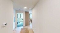 Located at 2450 S Barrington Ave in West Los Angeles, this thoughtfully designed 3-bedroom, 2-bathroom residence offers a clean, modern aesthetic across a single floor. The open-concept living room is anchored by light oak hardwood flooring, recessed lighting, and large black-framed sliding glass doors that open onto a private balcony, filling the space with natural light and providing outdoor views. The well-appointed kitchen features light wood cabinetry, dark stone countertops, stainless steel appliances, a textured tile backsplash, and a picture window above the sink. A central island with bar seating adds both function and style. The primary bedroom is comfortably sized, with large windows framing neighborhood views, plush carpet flooring, and clean white walls. The secondary bedrooms maintain the same minimalist character, with carpet underfoot and sliding closet doors. Both bathrooms are finished with hexagonal mosaic tile flooring, wood-framed vanity mirrors, and tub-shower combinations enclosed by glass doors and floor-to-ceiling grid-patterned tile. The overall ambiance is bright, contemporary, and move-in ready, reflecting a cohesive modern design sensibility throughout.