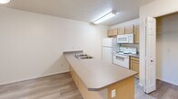 Located at 8519 W Fairview Ave in Boise, Idaho, this one-bedroom, one-bathroom unit offers a practical and well-organized layout across a single floor. The kitchen is a standout feature, designed with a peninsula-style counter that includes a double-basin sink, providing additional prep space and a natural divider between the kitchen and living areas. Light wood cabinetry offers ample storage, while white appliances — including a refrigerator, electric range, and over-the-range microwave — complete the functional setup. The flooring throughout the kitchen and hallway is a light wood-tone laminate, adding warmth and easy maintenance.

The bedroom is generously proportioned, finished with soft carpet flooring, neutral walls, and a window that invites natural light and views of surrounding greenery. A walk-in closet off the bedroom provides substantial storage, outfitted with wire shelving and hanging rods across multiple walls.

The bathroom features wood-tone cabinetry with a vanity, light laminate flooring, and a full tub-shower combination. A hallway connects the living spaces efficiently, contributing to the unit's clean, straightforward flow. Overall, the space presents a clean, move-in ready environment with a neutral palette suited to a variety of personal styles.
