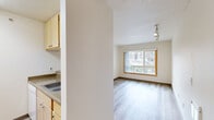 Located at 1240 SW Columbia St in Portland, Oregon, this one-bedroom, one-bathroom unit offers a thoughtfully organized single-floor layout. Light wood-style flooring flows consistently throughout the space, contributing to a clean, cohesive aesthetic.

The combined living and dining area serves as the heart of the unit, featuring a large wood-trimmed window that frames views of the surrounding Portland cityscape and greenery, filling the room with natural light. Track lighting on the ceiling provides adjustable illumination for the space. The kitchen is positioned adjacent to this open area, equipped with light wood cabinetry, a countertop sink, and functional storage.

The bedroom is a well-proportioned private retreat, also featuring a wood-trimmed window with city views and a wall sconce light fixture. A sliding wood-door closet provides dedicated storage, and two additional closets elsewhere in the unit offer further organizational flexibility.

The bathroom is clean and straightforward, featuring light wood-style flooring consistent with the rest of the unit, a vanity with warm wood cabinetry, a countertop sink, a bathtub, and chrome grab bars. Textured ceilings are present throughout the unit. An entrance foyer provides a defined transition point into the living space.