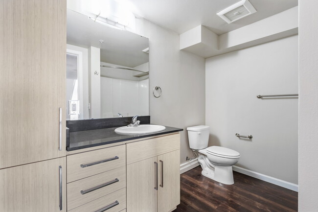 Experimente la comodidad de un baño moderno equipado con accesorios elegantes y amplia iluminación, ofreciendo un espacio relajante. - 1711 12th Apartments