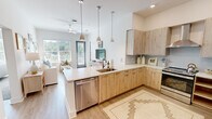 Located at 5102 Station Dr in Birmingham, Alabama, this well-appointed 2-bedroom, 3-bathroom residence offers a contemporary design with clean lines and a bright, neutral palette throughout. The open-concept layout connects the kitchen and living area seamlessly, creating an inviting and functional living space. The kitchen is a standout feature, showcasing light wood cabinetry, crisp white quartz countertops, a peninsula with an undermount sink, stainless steel appliances including a range with a wall-mounted hood, and a penny-tile backsplash. Pendant lighting adds a modern finishing touch above the peninsula. The living room is bathed in natural light from large windows and features light hardwood-style flooring, which carries throughout the main areas. Both bedrooms are carpeted and generously sized, with the primary bedroom offering a walk-in closet with built-in shelving. Each bathroom is finished with large-format marble-look tile in the tub and shower surrounds, light wood-tone flooring, and dark cabinetry vanities. A hallway connects the rooms efficiently, and two closets provide ample storage. The overall ambiance is modern, clean, and comfortable — an ideal residence in the heart of Birmingham.