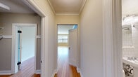 Located on the 10th floor at 1220 Boren Ave in Seattle's First Hill neighborhood, this one-bedroom, one-bathroom unit offers a well-organized layout across a single floor. Warm hardwood flooring runs throughout the main living areas and spacious bedroom, lending a classic, cohesive feel to the home. Crown molding adds an elegant architectural detail to both the living area and bedroom, which features a large window that brings in natural light and urban views of the surrounding cityscape. The bedroom includes its own closet, while a second closet elsewhere in the unit provides additional storage. The galley-style kitchen is efficiently designed with gray cabinetry, a mosaic tile backsplash, stainless steel appliances including a range and refrigerator, and a single-basin sink — maximizing functionality within a compact footprint. The bathroom is finished with classic white subway tile surrounding a full bathtub and shower combination, complemented by chrome fixtures for a clean, timeless look. A hallway connects the rooms, contributing to a logical and practical flow throughout the unit. The neutral color palette and traditional finishes create a calm, inviting atmosphere suited for comfortable urban living in the heart of Seattle.