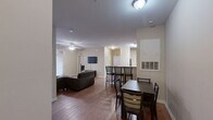 Located at 342 Walden Station Dr in Charlotte, NC, this single-floor unit offers three bedrooms and three full bathrooms within a well-organized and functional layout. The open-concept living and dining area serves as the heart of the home, featuring warm hardwood-style flooring, a ceiling fan, and a private exterior door that brings in natural light. A wall-mounted TV and comfortable seating make the living space ideal for relaxing or entertaining. The dining area accommodates a full-sized table, seamlessly connecting to the kitchen. The kitchen is well-appointed with light maple cabinetry, dark granite-style countertops, black appliances including a range, dishwasher, and microwave, plus a double sink — providing ample functionality for everyday cooking. Each of the three bedrooms offers hardwood-style flooring, neutral warm-toned walls, and windows with natural views, creating a calm and comfortable atmosphere. The bedrooms are versatile, accommodating both sleeping and study needs. The three full bathrooms each feature a clean white tub-shower combo with brushed nickel fixtures and tile flooring, maintaining a consistent, practical aesthetic throughout. The unit's neutral color palette and cohesive design provide a move-in-ready foundation.