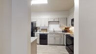This single-story residence in Cordova, Tennessee, offers a thoughtfully designed layout across three bedrooms and two full bathrooms. The kitchen serves as a standout feature, showcasing gray shaker-style cabinetry, granite countertops, a hexagonal tile backsplash, black appliances, and light wood-look tile flooring. A granite-topped peninsula provides additional prep space and connects seamlessly to the adjoining dining area, which features crown molding and wood-look flooring throughout.

The living room is bright and welcoming, highlighted by a ceiling fan, crown molding, a textured ceiling, and a set of large windows that invite natural light. Wood-look flooring continues here, adding visual cohesion throughout the common areas.

The bedrooms are carpeted and offer ceiling fans and ample closet space, including walk-in options. The primary bedroom includes access to a dedicated closet and connects to the hallway. Both bathrooms feature shaker-style vanities with marble-look countertops, white subway tile, and wood-look flooring. One bathroom includes a full tub-shower combination. The overall palette of neutral tones and consistent finishes creates a clean, cohesive aesthetic throughout the home.