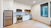 This 340 square foot studio apartment in Minneapolis offers a thoughtfully designed living space that maximizes functionality within a compact footprint. The open-concept layout seamlessly integrates living, sleeping, and dining areas, creating a sense of spaciousness. The kitchen is a highlight, boasting sleek white cabinetry, stainless steel appliances, and a subway tile backsplash. It's equipped with a full-size refrigerator, oven, microwave, and dishwasher, providing all the essentials for culinary endeavors. The bathroom features a clean, modern design with a bathtub-shower combination and ample storage. Light wood-look flooring throughout adds warmth and continuity to the space. Large windows allow natural light to flood the apartment, while roller shades offer privacy when needed. A wall-mounted air conditioning unit ensures year-round comfort. The apartment's neutral color palette and minimalist design create a blank canvas for personal style, making it an ideal home for those seeking efficient, low-maintenance urban living.