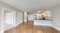 Located at 700 Citation Ln in Cherry Hill, NJ, this single-floor residence offers a clean, modern design with a thoughtfully organized open-concept layout. The heart of the home is a well-appointed kitchen featuring crisp white shaker cabinetry, dark granite countertops, stainless steel appliances including a refrigerator, microwave, and electric range, and a peninsula that connects seamlessly to the living area. Light wood-tone flooring runs throughout the main living spaces, complementing the neutral gray walls and white trim for a cohesive, contemporary aesthetic. The living area is generously sized and bathed in natural light, with large windows and sliding glass doors that open to a private balcony, offering views of the surrounding neighborhood. The bedrooms are carpeted for comfort, each featuring windows that bring in ample daylight; one bedroom includes a double closet with panel doors. The bathroom is finished with large-format tile flooring, a white vanity with dark countertop, and a full soaking tub with shower. Throughout the residence, clean lines, recessed lighting, and a consistent neutral palette create a bright and welcoming atmosphere suited for modern living.