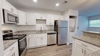 Located at 9704 Clark Place in Manassas, VA, this single-floor, one-bedroom, one-bathroom residence offers a thoughtfully designed layout with modern finishes throughout. Wood-look luxury flooring flows seamlessly across every room, providing a clean and cohesive aesthetic.

The kitchen serves as a functional centerpiece, equipped with stainless steel appliances including a refrigerator, range, microwave, and dishwasher. Crisp white shaker-style cabinetry extends to the ceiling for ample storage, while granite countertops add a refined touch. A peninsula with pendant lighting and additional counter seating connects the kitchen to the living area, enhancing the open-concept feel. An in-unit stacked washer and dryer is conveniently tucked adjacent to the kitchen.

The living room is generously windowed, with multiple large windows allowing abundant natural light and views of surrounding greenery. The bedroom continues this bright, airy character with additional windows and ample floor space.

The bathroom features classic beadboard wainscoting, a pedestal-style vanity, and brushed nickel hardware, creating a clean and timeless look. A dedicated closet provides practical storage. The overall ambiance is bright, modern, and move-in ready.