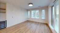 Located in the heart of downtown Raleigh, this well-appointed 2-bedroom, 2-bathroom residence offers a thoughtfully designed single-floor layout with modern finishes throughout. Light wood-tone flooring flows seamlessly across every room, creating a warm and cohesive aesthetic.

The open-concept kitchen and living area serves as the centerpiece of the home. The kitchen is outfitted with stainless steel appliances, two-tone cabinetry combining natural wood uppers with sage-green lowers, a tiled backsplash, white quartz countertops, and a central island. Stylish globe pendant lights hang above, adding a contemporary touch. The adjoining living area features large windows fitted with blinds, allowing abundant natural light and offering views of the Raleigh cityscape.

The primary bedroom is a generously sized retreat with a bank of windows framing urban views, complemented by a well-organized walk-in closet with built-in shelving and hanging systems. The second bedroom includes a ceiling fan and its own window with city views. Both bathrooms are finished with white subway tile surrounds, modern vanities with illuminated mirrors, and wood-look flooring. Additional spaces include a hallway, entrance, laundry room, utility room, and three closets, ensuring ample storage throughout.