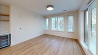 Located in the heart of downtown Raleigh, this well-appointed 2-bedroom, 2-bathroom residence offers a thoughtfully designed single-floor layout with modern finishes throughout. Light wood-tone flooring flows seamlessly across every room, creating a warm and cohesive aesthetic.

The open-concept kitchen and living area serves as the centerpiece of the home. The kitchen is outfitted with stainless steel appliances, two-tone cabinetry combining natural wood uppers with sage-green lowers, a tiled backsplash, white quartz countertops, and a central island. Stylish globe pendant lights hang above, adding a contemporary touch. The adjoining living area features large windows fitted with blinds, allowing abundant natural light and offering views of the Raleigh cityscape.

The primary bedroom is a generously sized retreat with a bank of windows framing urban views, complemented by a well-organized walk-in closet with built-in shelving and hanging systems. The second bedroom includes a ceiling fan and its own window with city views. Both bathrooms are finished with white subway tile surrounds, modern vanities with illuminated mirrors, and wood-look flooring. Additional spaces include a hallway, entrance, laundry room, utility room, and three closets, ensuring ample storage throughout.