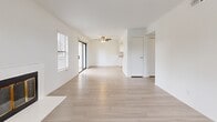 Located at 3364 Honeybrook Way in Ontario, CA, this single-story 2-bedroom, 2-bathroom home offers a clean, modern aesthetic defined by crisp white walls and light wood-look tile flooring that flows consistently throughout every room. The open living area is a standout space, featuring a classic fireplace framed in white, a ceiling fan, and sliding glass door access that fills the room with natural light. Multiple windows dressed with blinds enhance the bright, airy atmosphere. Adjacent to the living area, the galley-style kitchen is well-appointed with white shaker cabinetry, quartz-style countertops, stainless steel appliances including a range, microwave, and refrigerator, and a window above the sink for added natural light. The primary bedroom offers generous proportions with a window view of the surrounding area, while the second bedroom features a sliding closet and its own natural light source. Both bathrooms are finished in a cohesive white palette — one featuring a full tub-shower combo with chrome fixtures, and the other showcasing a wide vanity with white cabinetry and a framed mirror. A dedicated hallway and closet provide practical storage. The overall design is clean, neutral, and move-in ready.