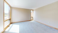 Located at 1598 Eustis St in Lauderdale, MN, this two-bedroom, one-bathroom unit offers a well-designed single-floor layout that makes efficient use of its space. The kitchen is a standout feature, outfitted with warm natural wood cabinetry, white countertops, stainless steel appliances including a gas range and full-size refrigerator, and light tile flooring. A kitchen island with pendant lighting overhead adds both function and style, while recessed lighting keeps the space bright and inviting. The combined kitchen and living area flows seamlessly, with plush light gray carpeting and warm wood trim carried throughout. Large wood-framed windows in the living room invite generous natural light and offer views of surrounding greenery. Both bedrooms are carpeted and feature wood-framed windows that bring in natural light and outdoor views. The primary bedroom is comfortably sized and includes access to a dedicated closet, providing practical storage. The bathroom is finished with clean white subway tile surrounding a full tub-shower combination with chrome fixtures. Neutral tones, warm wood accents, and consistent finishes throughout give this unit a cohesive and comfortable character.