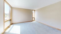 Located at 1598 Eustis St in Lauderdale, MN, this two-bedroom, one-bathroom unit offers a well-designed single-floor layout that makes efficient use of its space. The kitchen is a standout feature, outfitted with warm natural wood cabinetry, white countertops, stainless steel appliances including a gas range and full-size refrigerator, and light tile flooring. A kitchen island with pendant lighting overhead adds both function and style, while recessed lighting keeps the space bright and inviting. The combined kitchen and living area flows seamlessly, with plush light gray carpeting and warm wood trim carried throughout. Large wood-framed windows in the living room invite generous natural light and offer views of surrounding greenery. Both bedrooms are carpeted and feature wood-framed windows that bring in natural light and outdoor views. The primary bedroom is comfortably sized and includes access to a dedicated closet, providing practical storage. The bathroom is finished with clean white subway tile surrounding a full tub-shower combination with chrome fixtures. Neutral tones, warm wood accents, and consistent finishes throughout give this unit a cohesive and comfortable character.